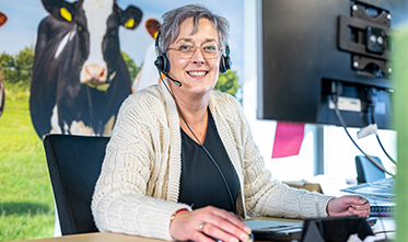 Medewerker KCA belt achter computer